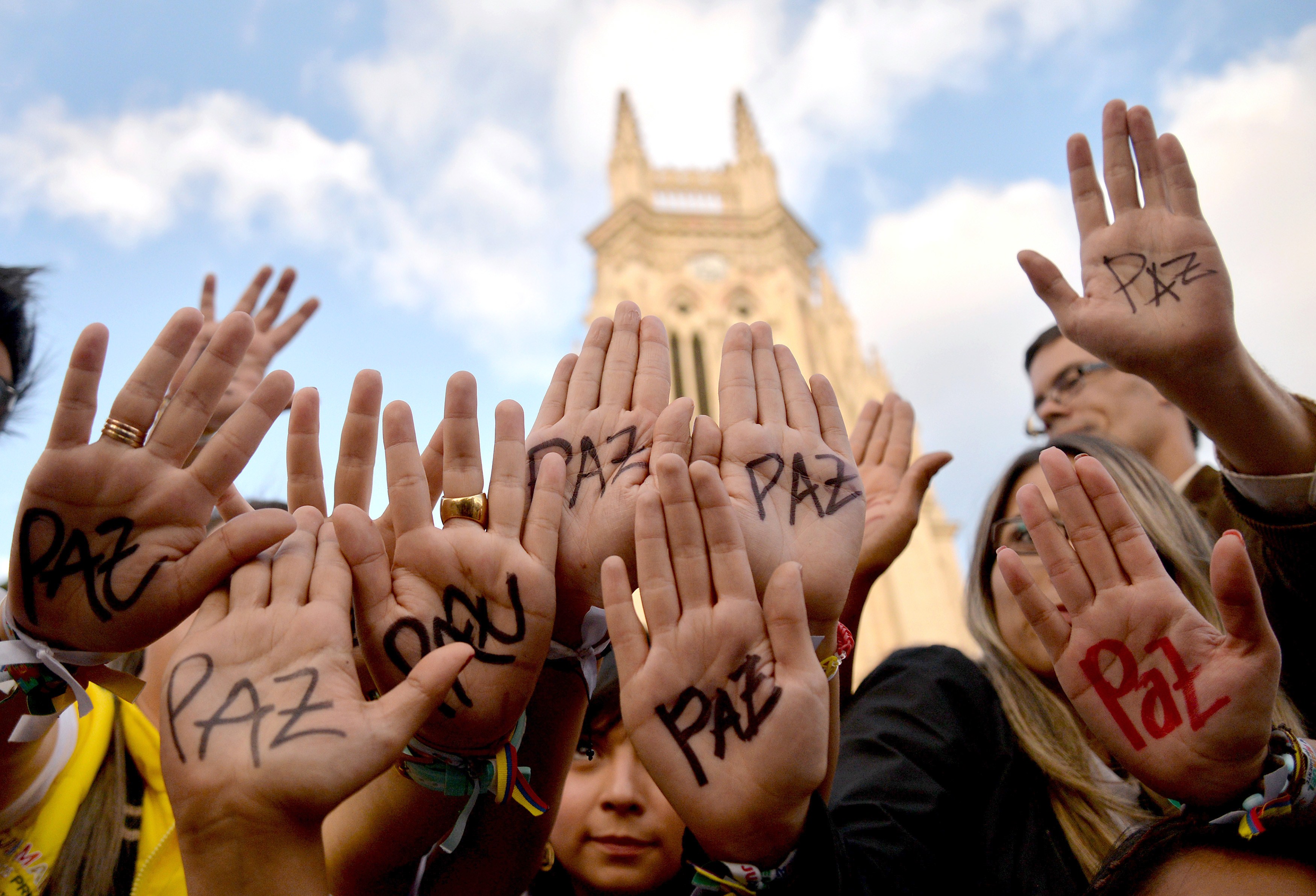 zzzzinte1Supporters of Colombian president and presidential candidate Juan Manuel Santos raise their hands with the word "Peace" written on them during a peace event in Bogota, on June 11, 2014. Colombia's government and the country's second largest guerrilla group, the National Liberation Army (ELN), announced on the eve they have opened peace talks, which adds to those taking place with the FARC, with a tense runoff presidential election just days away. AFP PHOTO/Diana Sanchez zzzz